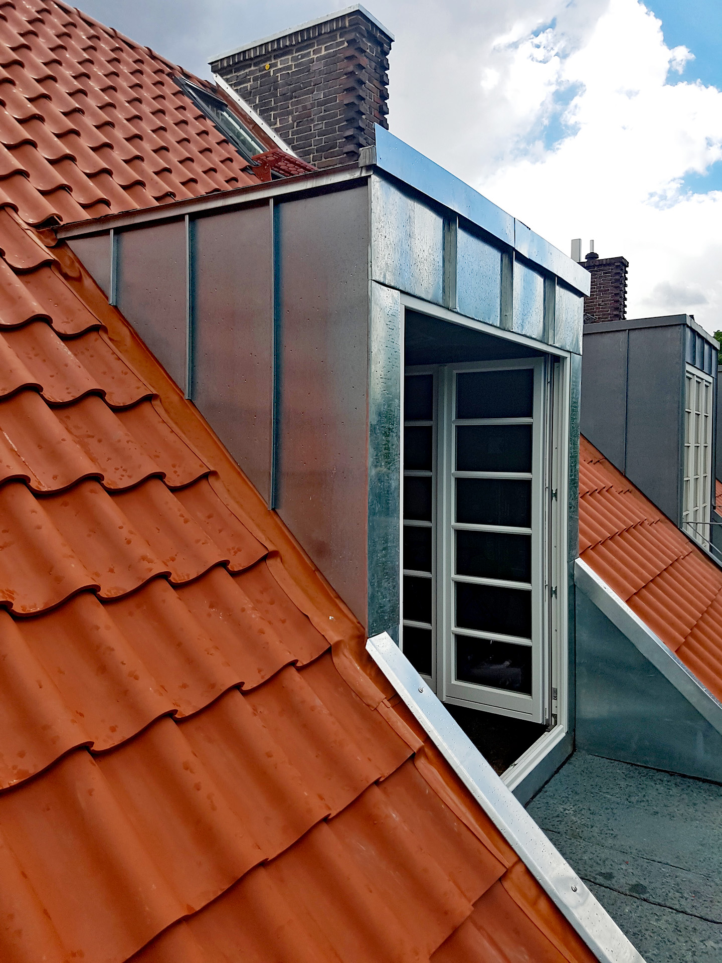 Eine hochwertig mit Metall verschalte Gaube mit Fensteraustritt zum Dachbalkon.